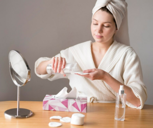 a girl carefully testing skin care products 